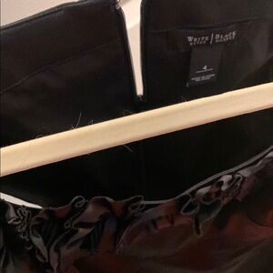 White House Black Market Black dress with decorative flowers at the neck line.